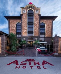 a building with a sign in front of it at Astra Hotel in Adler