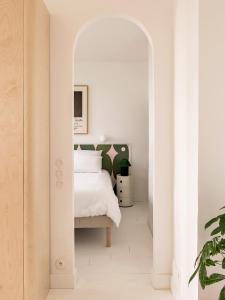 ベルサイユにあるSuperbe appartement design au coeur de Versailles, tout à piedの白いベッドルーム(ベッド1台、アーチ付)