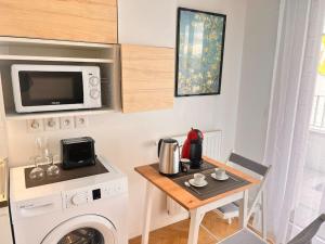 a kitchen with a washing machine and a table at Studio à 3 min Gare Massy-TGV in Massy