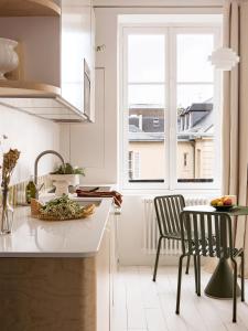 ベルサイユにあるSuperbe appartement design au coeur de Versailles, tout à piedの窓、テーブル、椅子付きのキッチンが備わります。 +15枚の写真