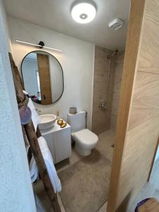 Un baño con inodoro, lavabo y espejo. en Calypso, en Chalkida