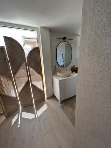 Un baño con espejo y lavabo en una habitación. en Calypso, en Chalkida