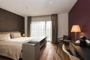 a hotel room with a bed and a desk with a telephone at Hotel Du Nord in Interlaken