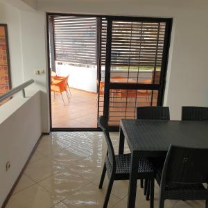 a dining room with a table and chairs and a balcony at Gamboa-1 Praia in Praia +10 photos