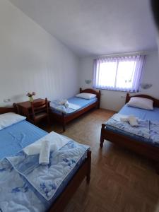 a room with two beds and a table and a window at Rooms Zdravko and Nevenka Cilic in Međugorje +97 photos