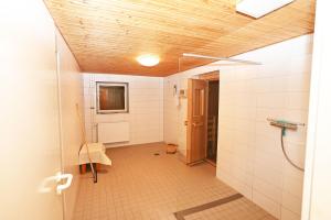 um banheiro com paredes de azulejos brancos e teto em Ferienwohnung Ilka WE 14 em Hohwacht