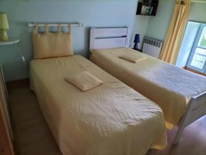 zwei nebeneinander stehende Betten in einem Schlafzimmer in der Unterkunft Maison charmante à Antezant-la-Chapelle avec jardin in Le Pin-Saint-Denis