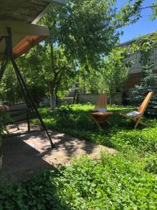 two chairs and a swing in a yard at TREFOIL in Lori Berd