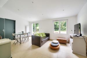 a living room with a couch and a table at 850m de la plage maison neuve pour 6 en foret in Saint-Vincent-sur-Jard