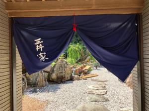 Tosaペットと泊れる一軒家三井家みついんく平家の母屋一棟貸切的建筑物上带有中文文字的蓝色窗帘