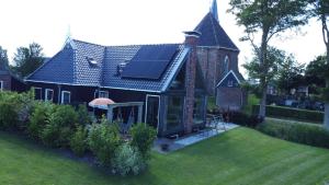 a house with a solar panel on the roof at Gastenverblijf lânlibben in Lioessens