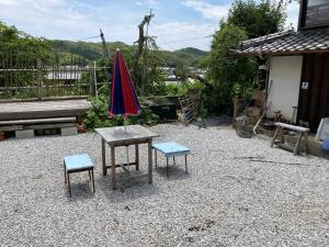 Tosaペットと泊れる一軒家三井家みついんく平家の母屋一棟貸切的一张桌子、两把椅子和一把伞