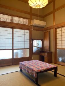 Tosaペットと泊れる一軒家三井家みついんく平家の母屋一棟貸切的带窗户的客房内的一张床位