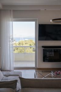 TV a/nebo společenská místnost v ubytování Athenian Riviera Sea View Penthouse