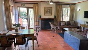 a living room with a couch and a table at White River Selfcatering at Greenway woods House no 9 in White River