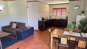 a living room with a couch and a table at White River Selfcatering at Greenway woods House no 9 in White River
