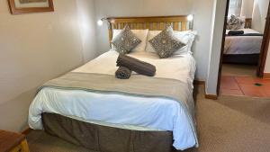 a bedroom with a bed with a suitcase on it at White River Selfcatering at Greenway woods House no 9 in White River +54 photos