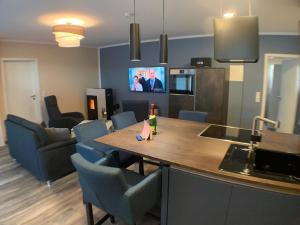 a kitchen and living room with a table and chairs at Renoviertes Ferienhaus in Harbshausen mit Terrasse, Grill und Garten in Vöhl +11 photos