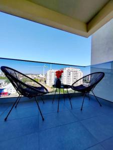 two chairs on a balcony with a view of a city at Studio President 52 in Craiova