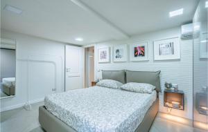 a white bedroom with a bed and a tv at 2 Bedroom Awesome Home In Orte in Orte