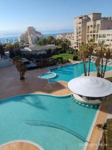 une grande piscine avec une fontaine en face de certains bâtiments dans l'établissement Apartamento reformado con terraza vistas al mar y a las piscinas de Magic World garaje y piscina frente a Balneario Aire acondicionadowifi, à Oropesa del Mar