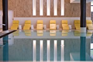 a row of yellow chairs sitting next to a pool at Thalazur Arcachon in Arcachon