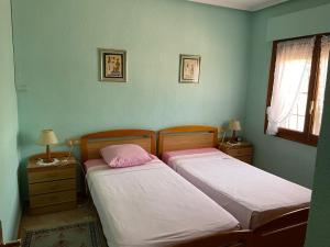 two beds in a bedroom with two lamps and a window at La Casita in Ciudad Quesada