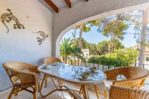 Charming Villa in Teulada with Private Pool في تيولادا: فناء مع طاولة وكراسي على شرفة