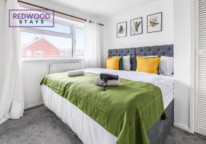 a bedroom with a bed with a green blanket at Cosy 3-Bedroom Serviced House with Free Fast WiFi and Parking for 2 Cars By Redwood Stays in Camberley