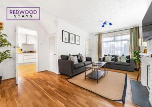 a living room with a couch and a table at Cosy 3-Bedroom Serviced House with Free Fast WiFi and Parking for 2 Cars By Redwood Stays in Camberley +14 photos