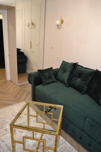 a living room with a green couch and a glass table at Park Gate apartment Новий Елітний ЖК біля Центрального парку in Chernivtsi +25 photos