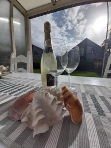 Una botella de vino y dos copas de vino en una mesa en Kustverhuur, Vakantiepark Fort Soleil 28, en Breskens
