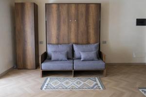 ein blaues Sofa in einem Zimmer mit Teppich in der Unterkunft ALETIA in Domodossola + 5 Fotos
