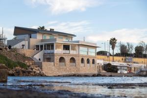 a house on the shore of a body of water at Le Suites sul Mare di Esterina in Civitavecchia