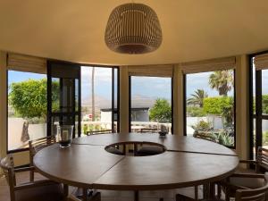 jadalnia ze stołem, krzesłami i oknami w obiekcie Villa Dora Bella Lanzarote w mieście Nazaret