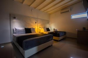 a bedroom with two beds and a couch at Naiot Hotel Boutique in Medellín +32 photos