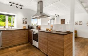 a kitchen with wooden cabinets and a stove top oven at Broagerland ferielejlighed Sønderborg Gråsten in Broager
