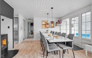 a dining room with a table and chairs and a fireplace at Lovely Home In Væggerløse With Wifi in Marielyst