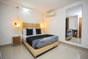 a bedroom with a large bed and a mirror at Naiot Hotel Boutique in Medellín
