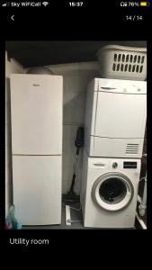 a kitchen with a washing machine and a refrigerator at Dolly Cottage Colchester in Mile End