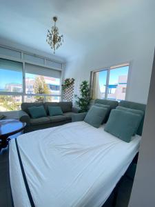 a large white bed in a room with a couch at Appartement prestigieux à Smir Park M'diq in Marina Smir +15 photos