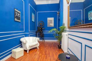 a blue room with a white chair and a mirror at Opera Venice Apartment in Mestre