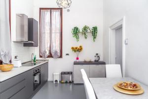a kitchen with a table with a pizza on it at Opera Venice Apartment in Mestre