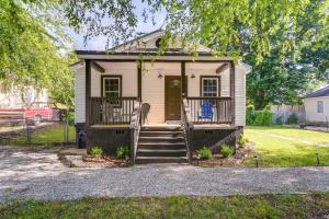 una pequeña casa con un porche y una escalera en Charming Greenville Home with Yard 3 Mi to Downtown, en Greenville