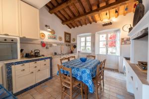 a kitchen with a table with a blue and white table cloth at Villa Il Guardingo in Rio nellʼElba +75 photos