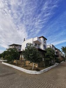 a white building on the side of a street at Kuşadası Davutlar'da Huzur Rahat ve Konfor Bir Arada in Aydın