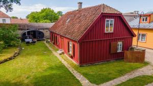 a red house with a red roof in a yard at Mönus Pesa in Kuressaare