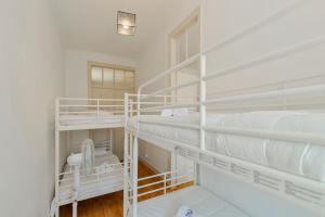 a white room with two bunk beds in it at Mercy House - BY Y Concept in Setúbal