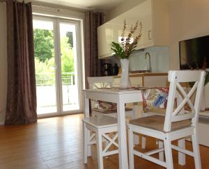 a kitchen with a table and chairs and a vase with flowers at Apartamenty Miku - Polanica-Zdrój in Polanica-Zdrój
