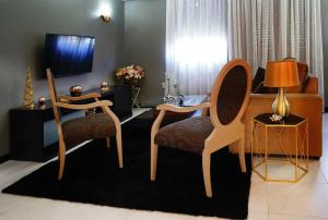 a living room with two chairs and a television at Minho Valley in Caminha